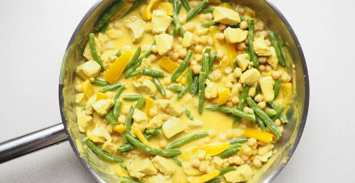 Pyszne, aromatyczne **yellow curry** z kurczakiem, fasolką szparagową i ciecierzycą w kremowym sosie.