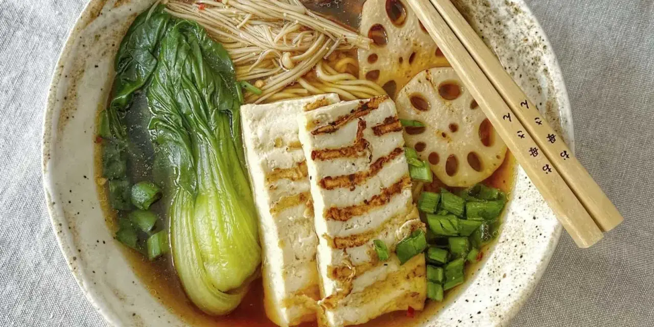 Aksamitny vege ramen z grillowanym tofu, pak choi, grzybami enoki i plasterkami lotosu. Idealny na chłodny wieczór.