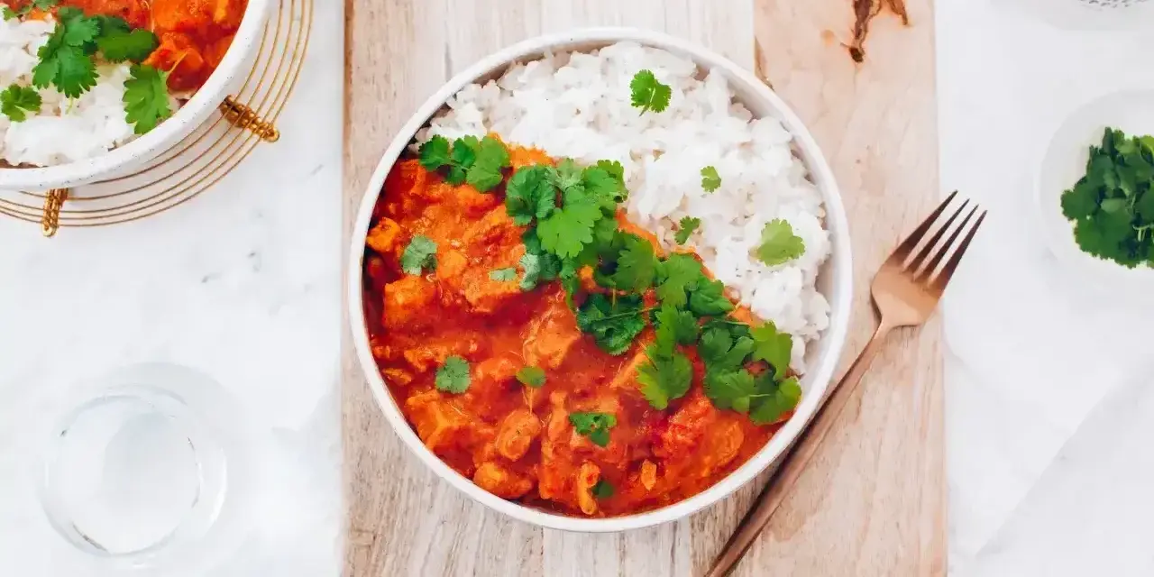 Pyszny red curry przepis z kurczakiem i ryżem, udekorowany świeżą kolendrą. Idealny na obiad.