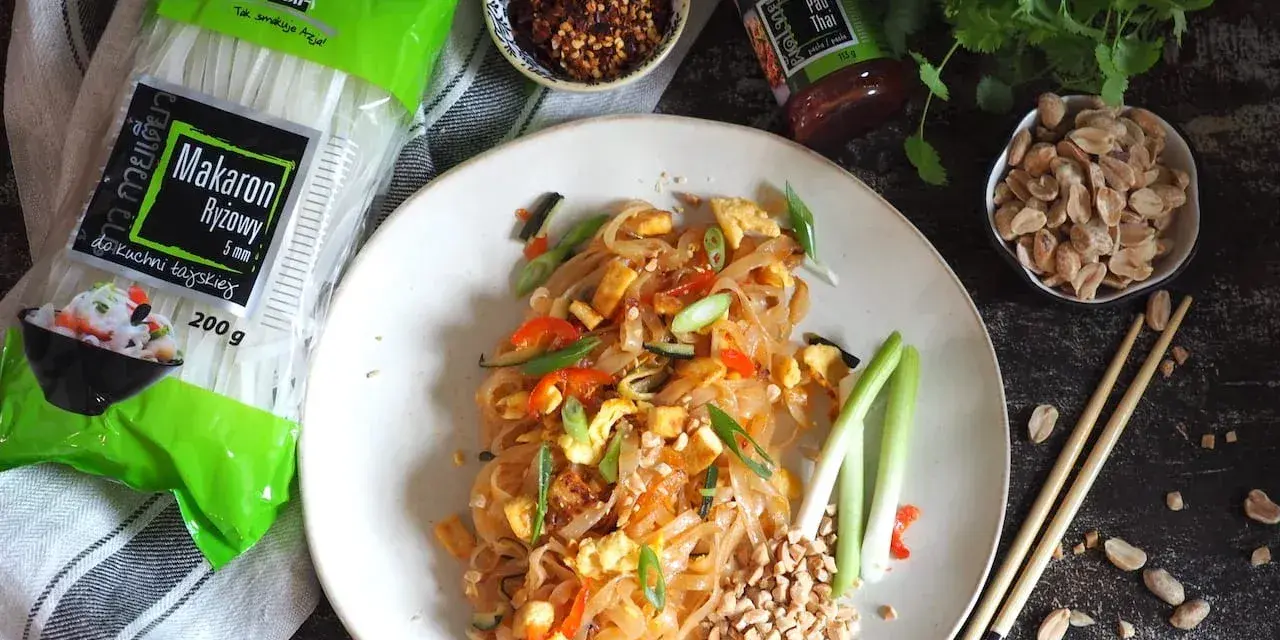 Pyszny pad thai z jajkiem, makaronem ryżowym i orzeszkami ziemnymi, gotowy do spożycia.