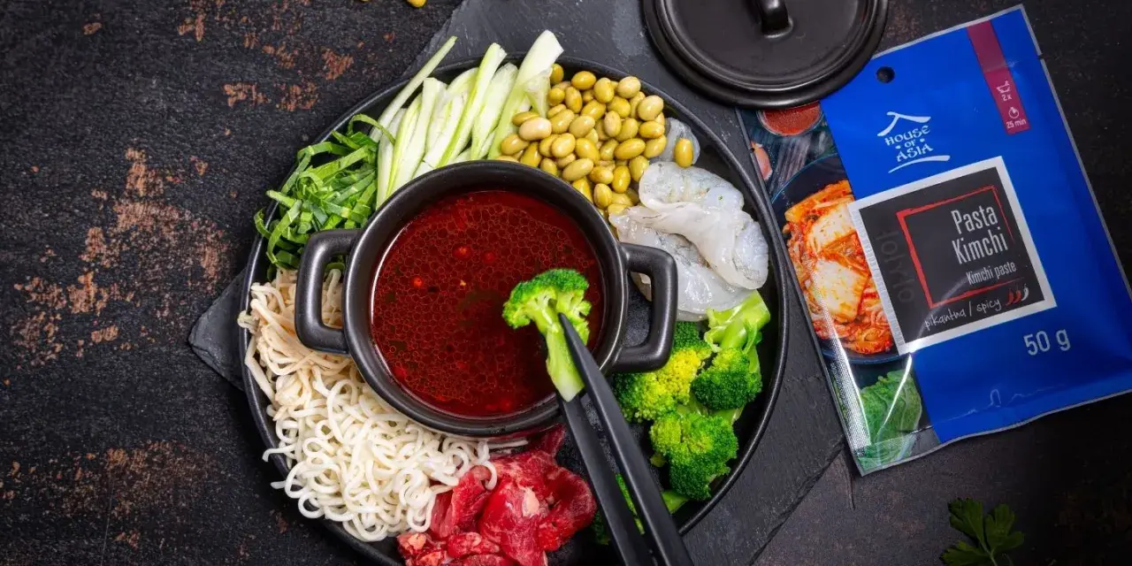 Składniki do hot pot z pastą kimchi: makaron, krewetki, wołowina, brokuły, fasolka edamame, ogórek i zielenina.