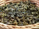Suszone liście herbaty gunpowder w wiklinowym koszyku. Odkryj jej niezwykłe właściwości!