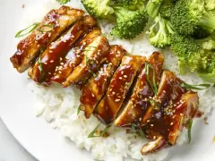 Pyszny kurczak w marynacie teriyaki, podany z ryżem i brokułami. Posypany sezamem i szczypiorkiem.
