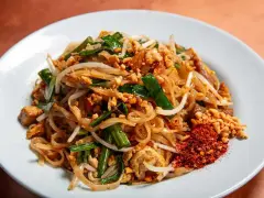 Pyszny pad thai z ryżowym makaronem, kiełkami, orzeszkami i chili. Idealny makaron do pad thai to cienki, płaski ryżowy.