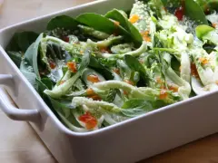 Pyszna kapusta pak choi po tajsku, polana sosem i posypana sezamem, w białej ceramicznej misie.
