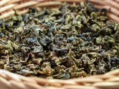Suszone liście herbaty gunpowder w wiklinowym koszyku. Odkryj jej niezwykłe właściwości!