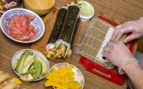 Przygotowanie sushi: ryż, awokado, mango, krewetki i marynowany imbir czekają na rolki. Zobacz nasz sushi przepis!