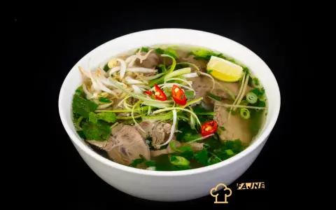 Aromatyczne zupy azjatyckie: pho z wołowiną, kiełkami, chili i limonką. Pyszne danie na czarnym tle.