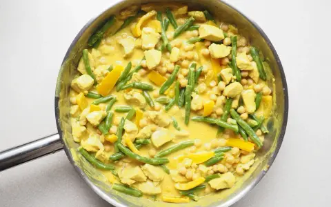Pyszne danie curry z kurczakiem, fasolką szparagową i ciecierzycą w kremowym sosie.