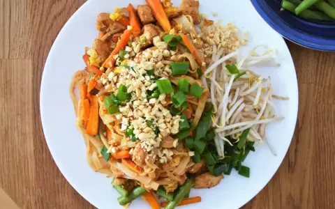 Pyszny Pad Thai z kurczakiem, warzywami i orzeszkami ziemnymi, polany aromatycznym sosem do Pad Thai.