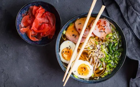 Miseczka z marynowanym imbirem i aromatyczny ramen z jajkiem i plastrami mięsa. Idealne, co podać oprócz sushi.