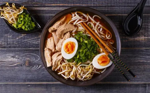 Miseczka aromatycznego ramenu z kurczakiem, jajkiem i kiełkami fasoli. Czy ramen jest zdrowy? Zależy od składników, ale ten wygląda apetycznie i pożywnie.