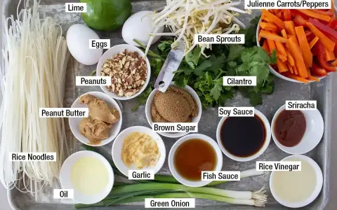 Składniki do sosu pad thai: makaron ryżowy, jajka, orzeszki ziemne, masło orzechowe, fasolka mung, marchewka, papryka, kolendra, sos sojowy, cukier brązowy, czosnek, olej, zielona cebulka, sos rybny, ocet ryżowy, sriracha.