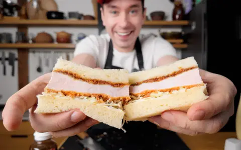 Uśmiechnięty mężczyzna prezentuje pyszne katsu sando z soczystym kotletem schabowym w panierce, delikatną kapustą i puszystym chlebem.