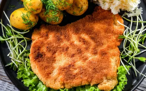 Chrupiący schabowy w panko, podany z młodymi ziemniaczkami, surówką i kiełkami. Pyszny obiad gotowy!