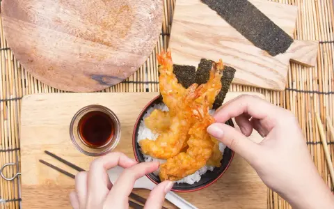 Chrupiące krewetki w cieście tempura na ryżu, gotowe do jedzenia. Idealny przepis na tempurę.