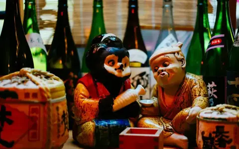 Figurki tanuki i starca z sake. Dowiedz się, jak pić sake, by poczuć japoński klimat.