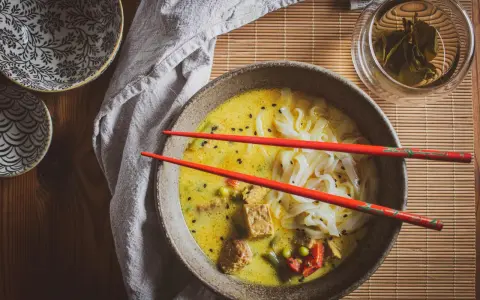 Aksamitna zupa laksa z makaronem ryżowym, tofu i warzywami. Idealny przepis na rozgrzewający posiłek.
