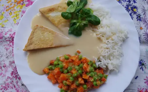 Trójkątne kawałki tofu w kremowym sosie madras, podane z ryżem i warzywami.