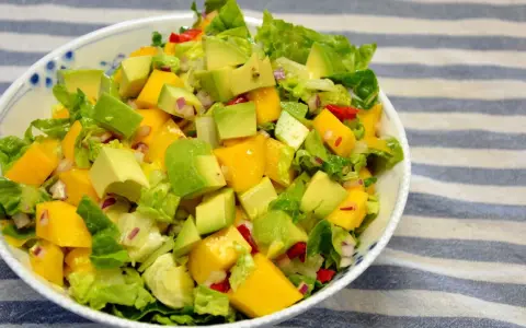 Orzeźwiająca sałatka z awokado, mango i czerwoną cebulą, polana lekkim sosem mango do sałatki.