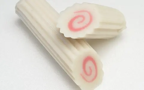 Dwa kawałki narutomaki, japońskiej rybnej pasty z różową spiralą w środku.