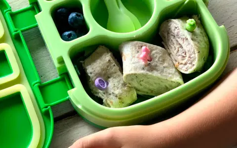 Kolorowy bento box z tortillami, jagodami i warzywami. Idealny lunchbox dla dziecka, który zachęca do jedzenia.