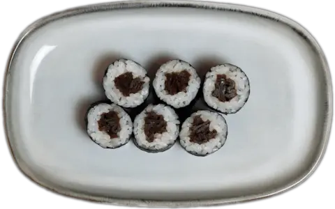 Sześć kawałków sushi z ryżem i ciemnym nadzieniem na szarej tacy.