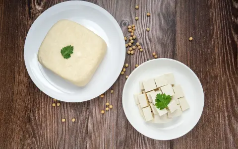 Kostka tofu i pokrojone w kostkę tofu na talerzach, gotowe do przygotowania pysznego tofu przepisu.
