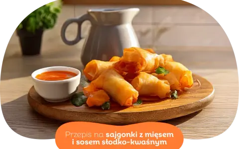 Chrupiące wege sajgonki z warzywami i sosem słodko-kwaśnym na drewnianej desce. Idealne na przekąskę.