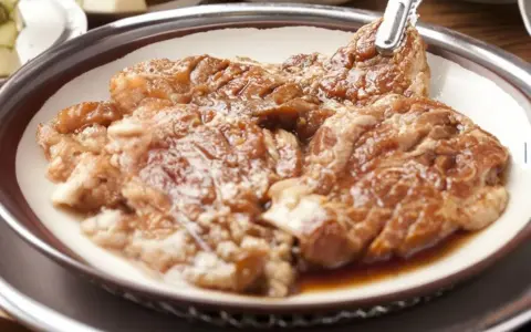 Soczysta karkówka z sosem sojowym i ketchupem, gotowa do grillowania.