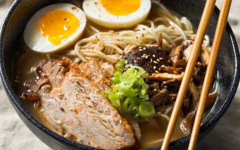 Miseczka aromatycznego ramenu z plastrami mięsa, jajkiem na pół i grzybami. Idealny ramen na szybko, by zaspokoić głód.