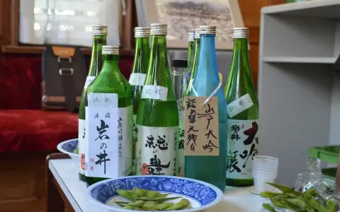 Butelki z japońskim alkoholem, idealne, gdy szukasz, czym zastąpić sake. Obok miseczka z edamame.