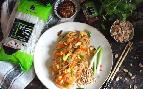 Pyszny pad thai z jajkiem, makaronem ryżowym i orzeszkami ziemnymi, gotowy do spożycia.