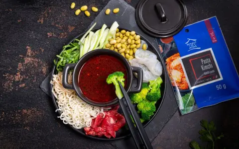 Składniki do hot pot z pastą kimchi: makaron, krewetki, wołowina, brokuły, fasolka edamame, ogórek i zielenina.