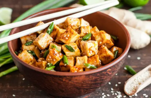 Miseczka pysznego, glazurowanego tofu z sezamem i szczypiorkiem. Zastanawiasz się, ile kcal ma tofu? To zdrowe i sycące danie!