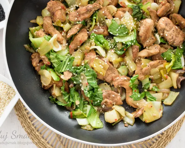 Smażony kurczak z pak choi, posypany sezamem, gotowy do podania.