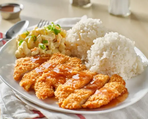 Chrupiący kurczak w panko polany sosem, podany z ryżem i sałatką makaronową. Pyszny obiad!