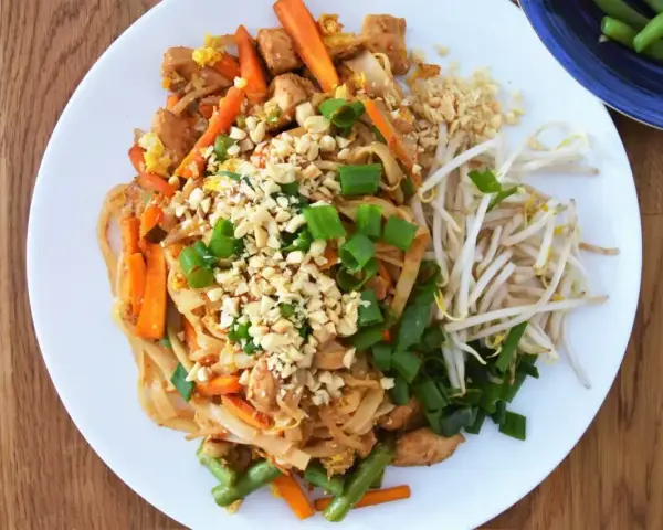 Pyszny Pad Thai z kurczakiem, warzywami i orzeszkami ziemnymi, polany aromatycznym sosem do Pad Thai.