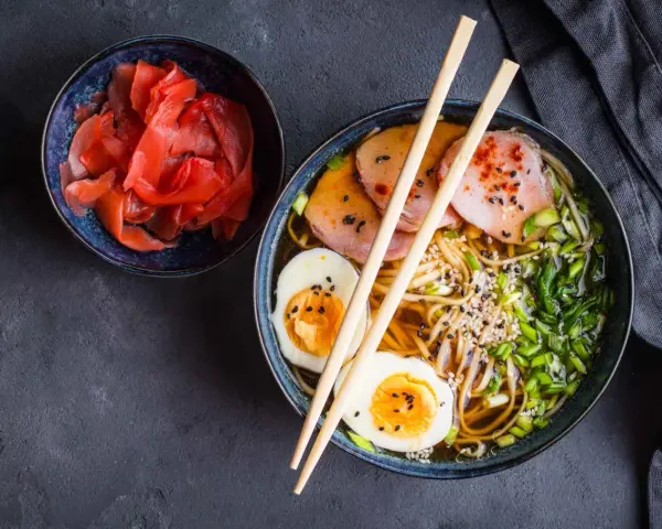 Miseczka z marynowanym imbirem i aromatyczny ramen z jajkiem i plastrami mięsa. Idealne, co podać oprócz sushi.