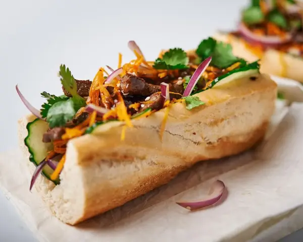 Pyszny banh mi przepis: bagietka z wołowiną, ogórkiem, marchewką, czerwoną cebulą i kolendrą.