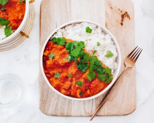 Aksamitny kurczak w czerwonym curry, podany z ryżem i świeżą kolendrą. Idealny na rozgrzewający posiłek.