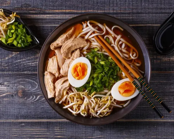 Miseczka aromatycznego ramenu z kurczakiem, jajkiem i kiełkami fasoli. Czy ramen jest zdrowy? Zależy od składników, ale ten wygląda apetycznie i pożywnie.
