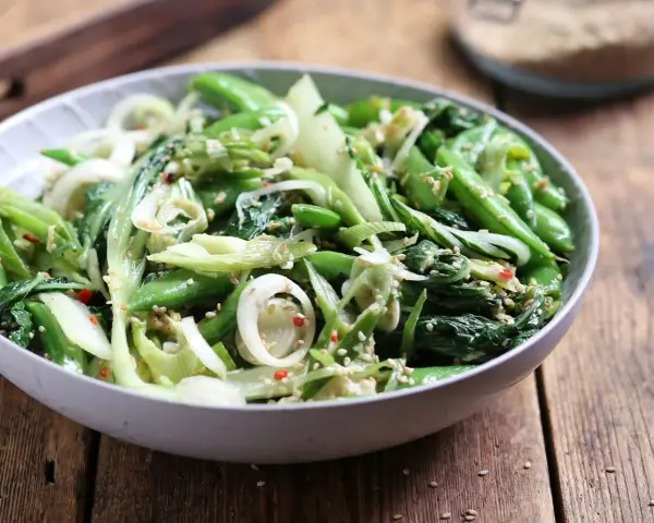 Zielona sałatka z pak choi, groszku cukrowego i cebuli, posypana sezamem. Idealna do dań kuchni azjatyckiej, świetne kapusta pak choi przepisy.