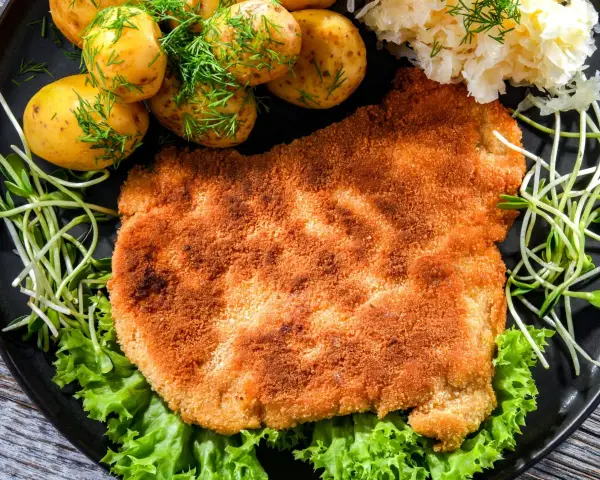 Chrupiący schabowy w panko, podany z młodymi ziemniaczkami, surówką i kiełkami. Pyszny obiad gotowy!