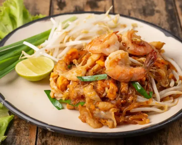 Pad Thai z krewetkami, kiełkami i limonką. Pyszne tajskie przepisy na talerzu.