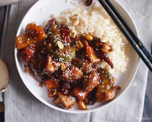 Pyszne danie kung pao z kurczakiem, warzywami i orzeszkami ziemnymi, podane z ryżem.