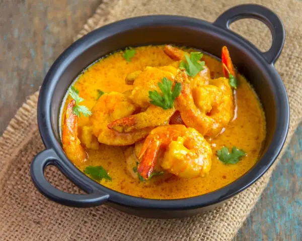 Aksamitny sos curry otula soczyste krewetki, tworząc danie pełne smaku.