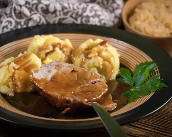 Soczysta karkówka w sosie sojowym, podana z purée ziemniaczanym i surówką. Pyszny obiad gotowy do spożycia.