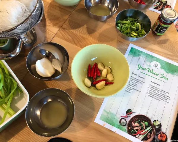 Składniki do zupy **sos tom yum**: czosnek, chili, zielona cebulka, makaron i pasta **sos tom yum** w słoiczku.