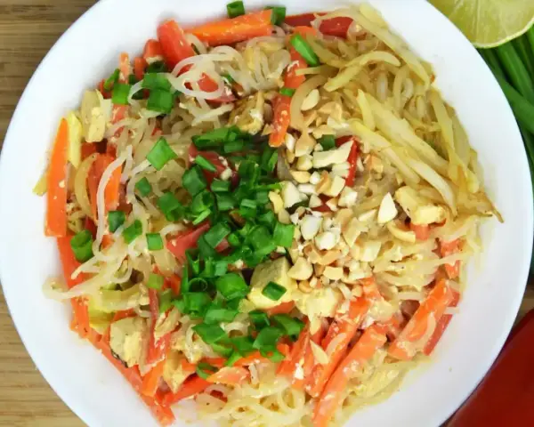 Talerz pełen pad thai z marchewką, tofu i orzeszkami ziemnymi. Zastanawiasz się nad pad thai kcal?